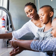 Mom helps her kids wash their hands properly